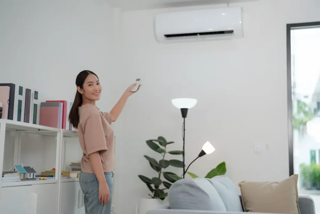 mujer controlando aire acondicionado inverter 1 ventajas aire acondicionado inverter